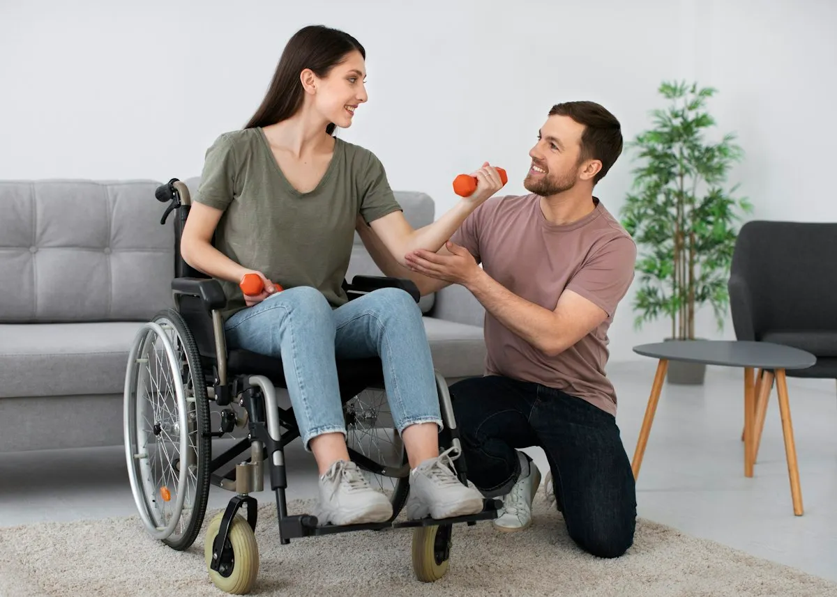 Mujer en silla de ruedas haciendo ejercicio con mancuernas mientras un fisioterapeuta la acompaña