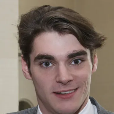 RJ Mitte, actor de Breaking Bad con parálisis cerebral, sonriendo en traje y corbata